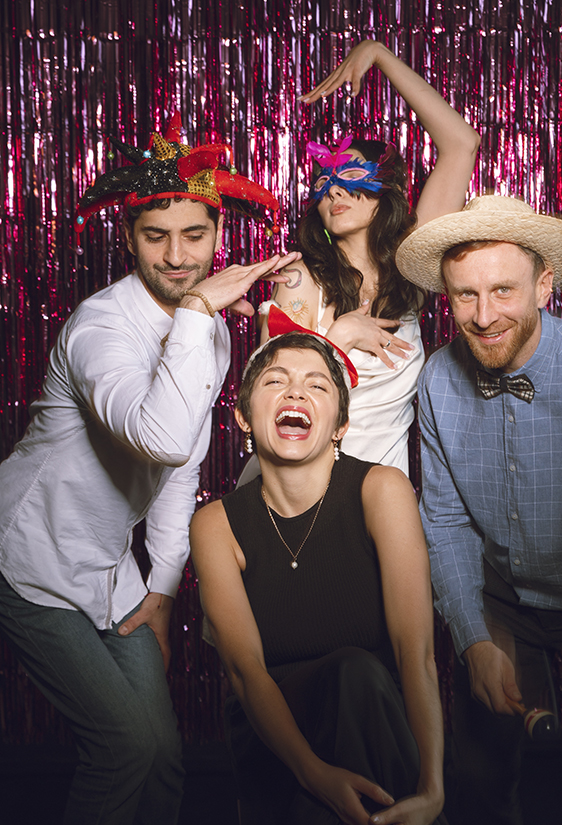 4 personnes qui posent devant un photobooth